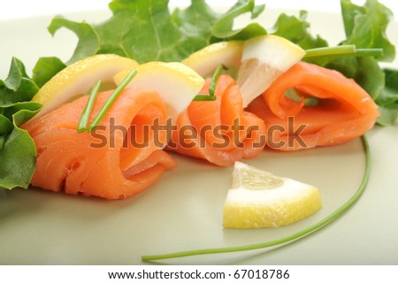 Close-up of smoked salmon served on plate with lemon and salad