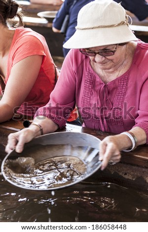 Senior woman tourist panning for gold in Fairbanks