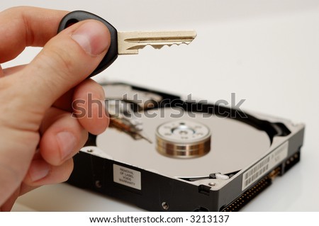 Hard disk and a key in a hand - conceptual photo - access to data