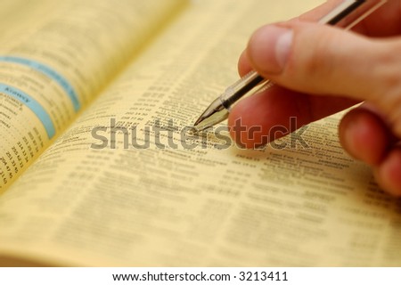 Hand holding a pen an a phone book