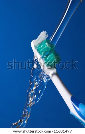 Toothbrush under water over blue background - hygiene concept