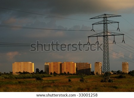 Power line and the city buildings at sunset