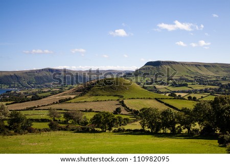 Countryside around the village of Cushendall in the Glens of Antrim, Ireland, under a summer sky.