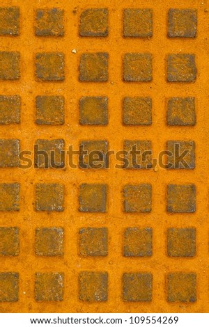 Great rusty iron metal sewer lid background. Yellow rusty steel details.