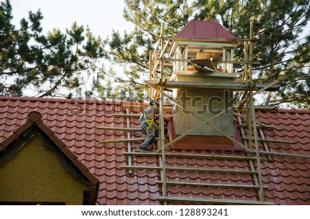 worker men with helmet covering roof with tiles. construction industry detail.