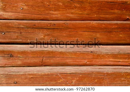 Background of ancient shaved painted wooden log wall and rusty nail heads.