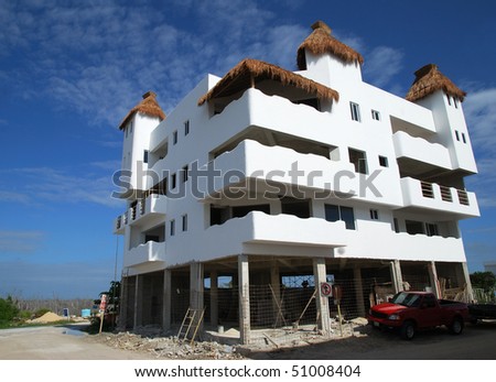 The construction site of the building with characteristic straw roofs in Mahahual resort town (Mexico).