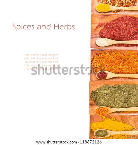 Background with spices and herbs - Different colored ground spices powders and solid with wooden spoons in a wooden coasters isolated on white background