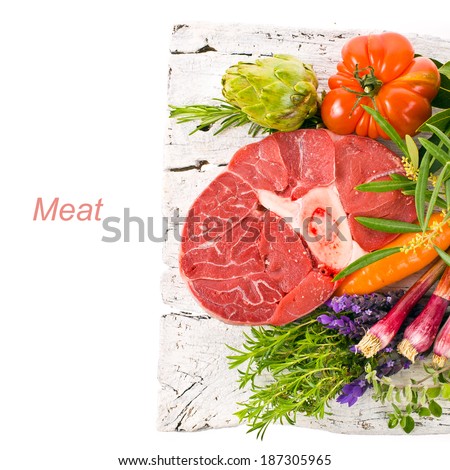 meat, a large piece of fresh meat, beef, to be on the old white boards, decorated with greens and vegetables isolated on white background