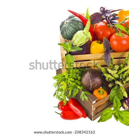 Different fresh vegetables and culinary herbs  lie in colored wooden boxes  isolated on white background
