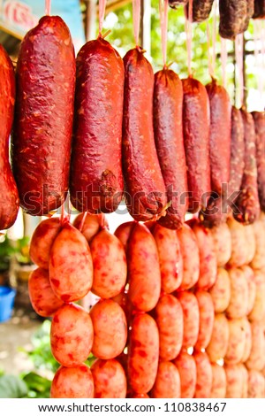 Home made meat salami sausage at street market hanging in line under sunlight to make good tasty
