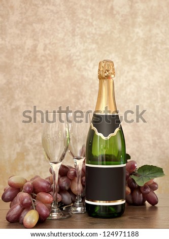 Bottle of sparkling wine, two glasses and grapes