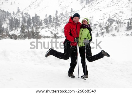 young couple posing having fun in the snow covered country