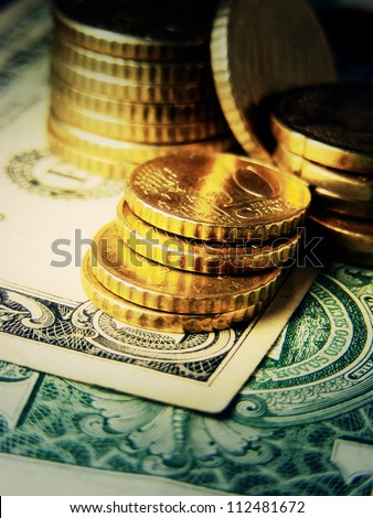 Euro coins on a dollar. Finance system concept.
