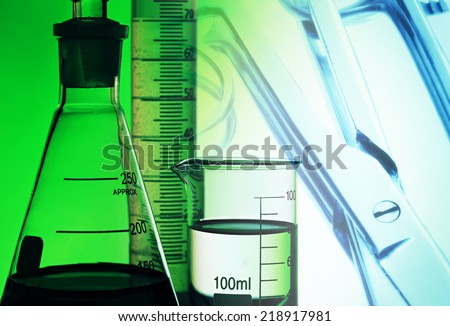 Laboratory glassware in green light. Science concept.