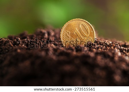 Money growth. Euro coins growing from soil.