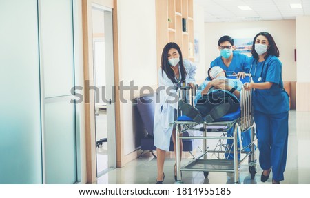 Similar – Image, Stock Photo Group of doctors transporting patient to operating room