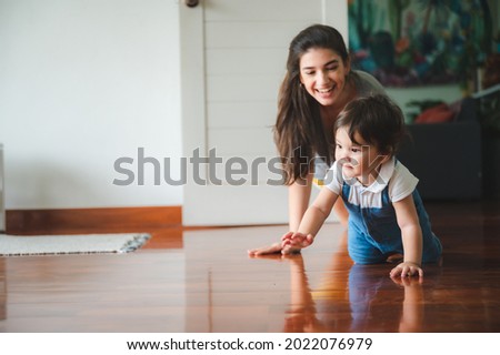 Similar – Image, Stock Photo Toddler learning to walk using push toy; child reaching to play with toy on front of walker