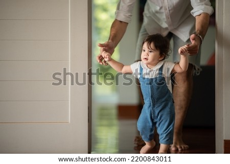 Similar – Image, Stock Photo Toddler learning to walk using push toy; child reaching to play with toy on front of walker