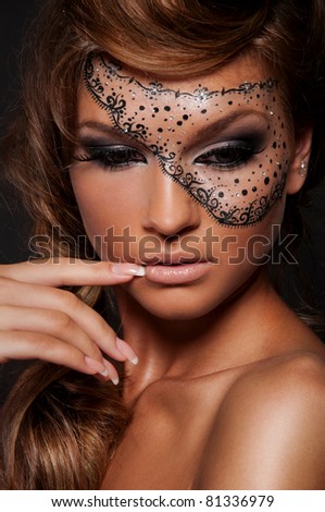 Pretty woman with creative makeup , mask on women\'s face