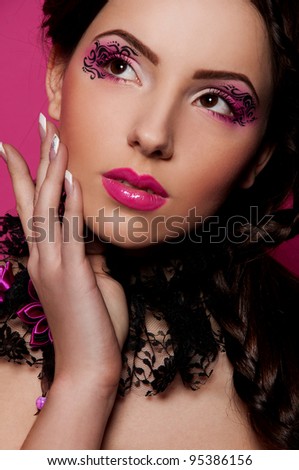 pretty woman with creative makeup and hairstyle on pink background
