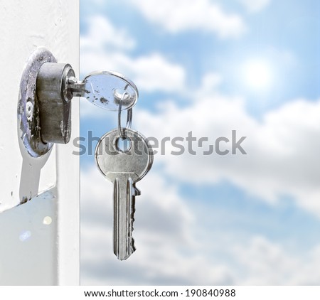 Keys in a lock with sky background