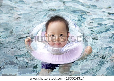 Baby with neck swim ring in the pool