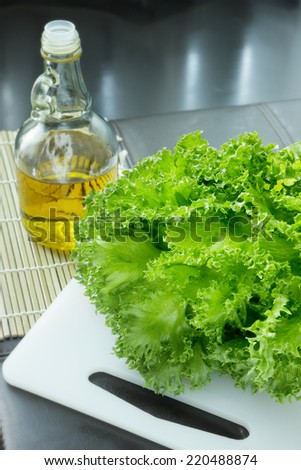 Fresh green lettuce with a bottle of olive oil,  top-right corner copy space