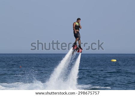 CAMYUVA, KEMER, TURKEY - JULY 12, 2015: Unidentified Turkish man hovered above the water. Extreme water sports are increasingly popular on the beaches of Turkey