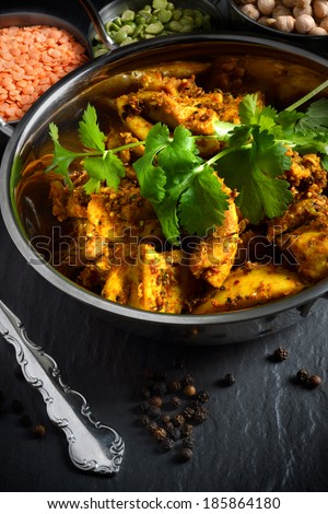 Bombay spiced potatoes and cubed chicken thighs with coriander leaves. Shot in natural light with lentils and chickpeas. The perfect image for a restaurant cover design.