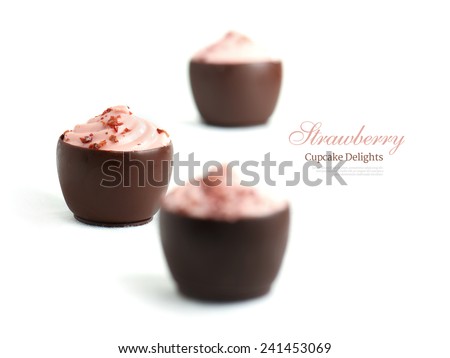 Softly lit homemade strawberry cupcake chocolates against a white background with soft shadows. Copy space.
