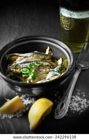 Spanish boquerones in olive oil in a rustic setting with differential focus shot in natural light. Copy space.