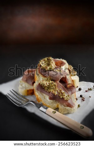 The ultimate beef and wheat grain mustard open sandwich against a dark background. Copy space.