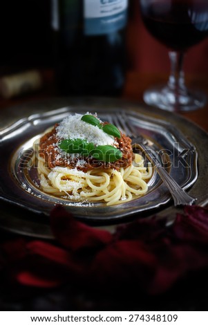 Freshly prepared Spaghetti Bolognese from an authentic Italian recipe with grated parmesan cheese and basil garnish. The perfect image for an Italian restaurant menu cover design.