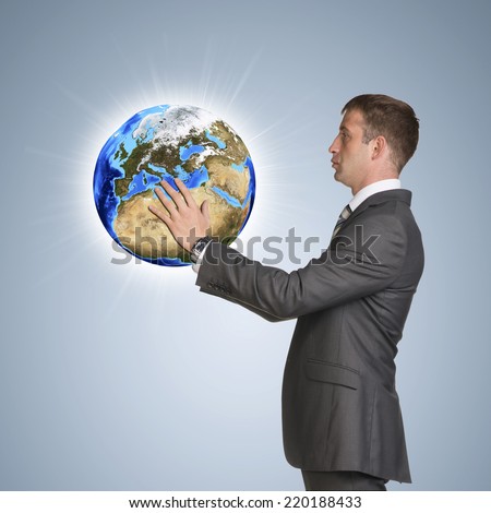 Businessman in suit hold Earth. Elements of this image are furnished by NASA