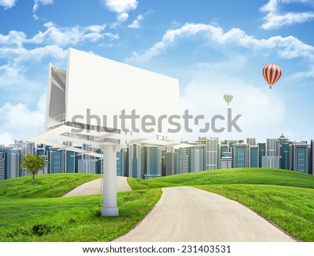 Tall buildings, green hills and road with large billboard against sky with clouds. Architectural concept