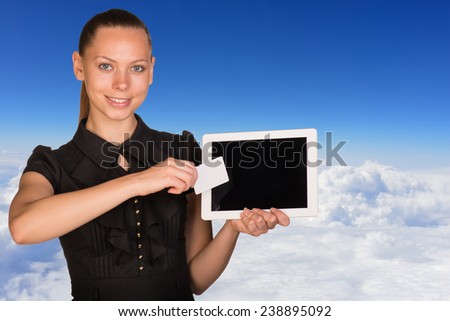 Beautiful businesswoman holding blank tablet PC and blank business card in front of PC screen. Blue sky and cloud layer as backdrop
