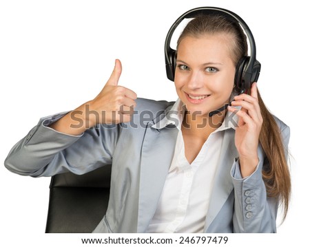 Businesswoman in headset showing thumb up, her other hand on microphone boom, looking at camera, smiling. Isolated over white background