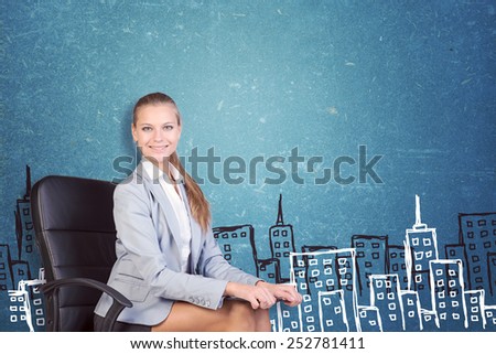 Businesswoman sitting on office chair with clipboard on her knees, looking at camera, smiling, in front of scratched wall with sketch of city