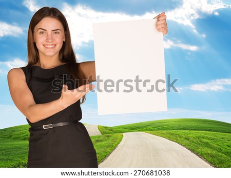 Young woman holding blank poster with nature on background. Place for constraction