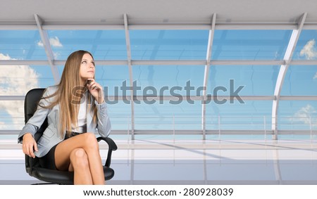 Thinking businesswoman sitting in chair with crossed legs and looking up