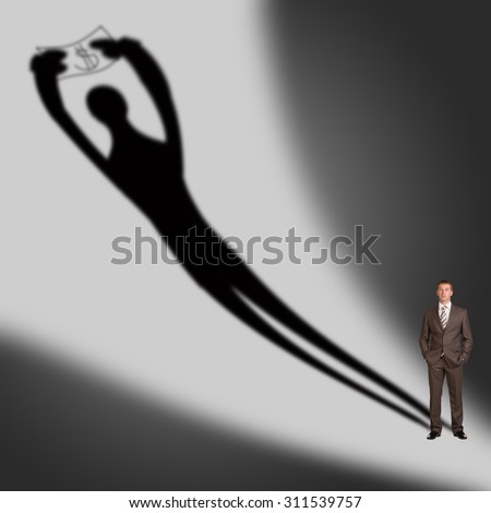 Businessman with shadow on gray wall background