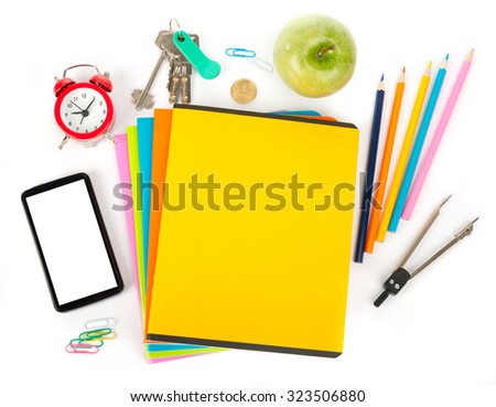 Pencil cup with crayons, smartphone and apple on copybooks on isolated white background