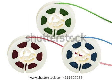 Three film tape reels with RGB colors separated on white