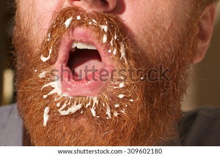 Very red beard male with a filth on the mustache and the beard in white color, could be a cream or milk or yogurt