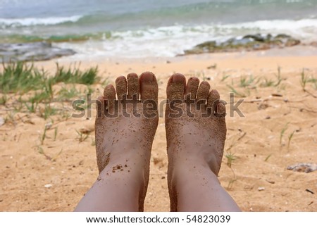 sandy bare feet against Hawaii island ocean