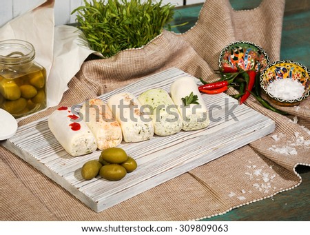 Russian kitchen and food. Spicy cheese rolls with herbs, olives, peppers and sea salt