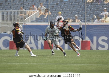 FOXBOROUGH - 28 MAY: Owen Blye (13), Maryland, College Park, moves teh ball against Joe Fletcher (17), Loyola University Maryland, at the NCAA Men\'s Division 1 Lacrosse Championship game, 28 May 2012 in Foxborough, Massachusetts