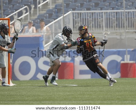 FOXBOROUGH - 28 MAY: Kevin Cooper (41), University of Maryland, College Park, makes a drive to the goal against a Loyola defender at the NCAA Men\'s Division 1 Lacrosse Championship game, 28 May 2012 in Foxborough, Massachusetts