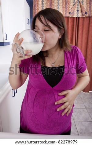 Young pregnant woman drinking milk